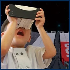 子供がデバイスを顔にかざし、何かを熱心に観察している