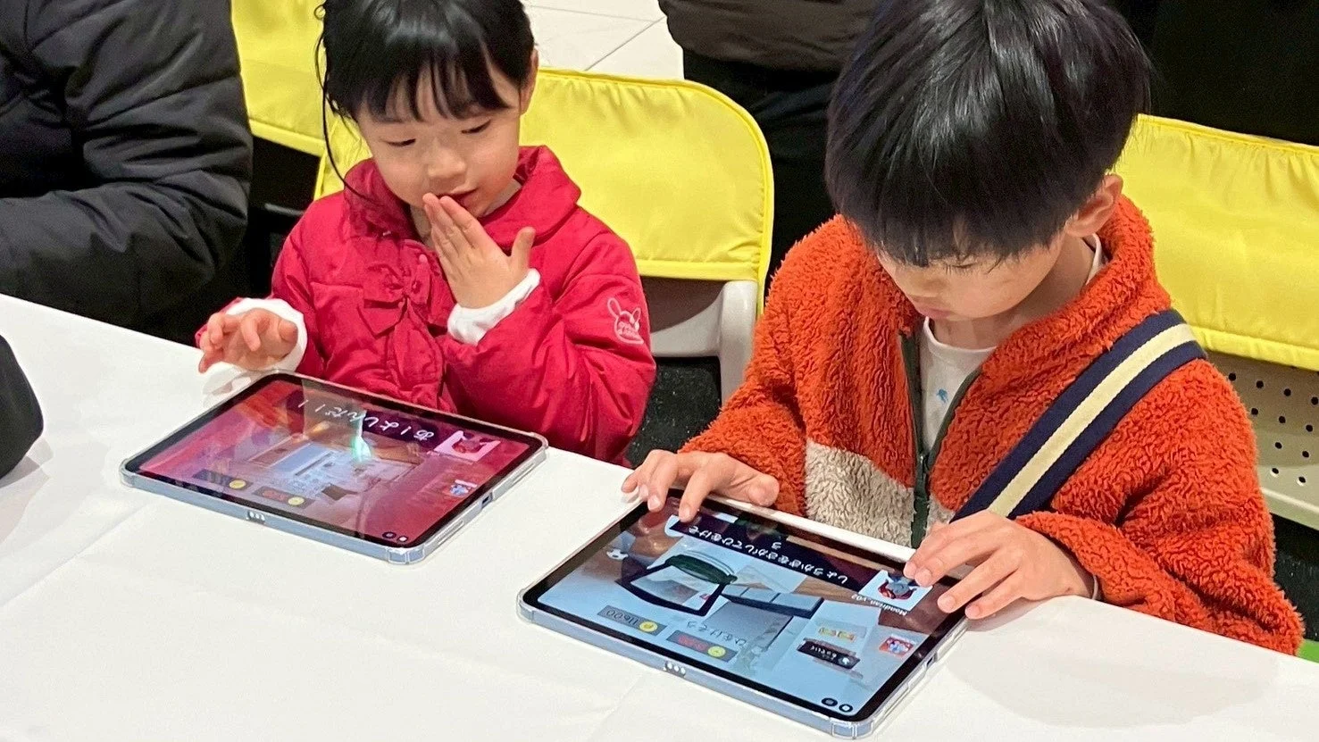 タブレットを操作し学習する二人の子供