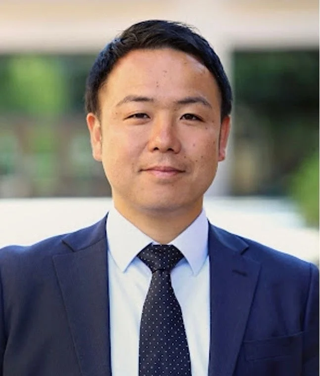 紺色のスーツと水玉模様のネクタイを着用したアジア系の男性