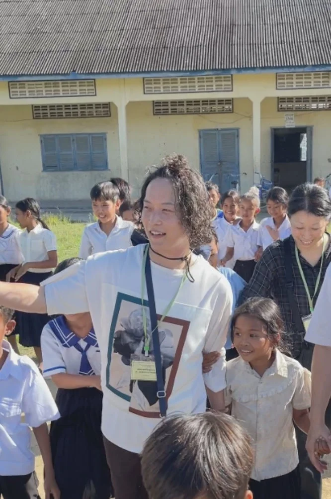 屋外で多くの子どもたちと大人たちが笑顔で交流している様子