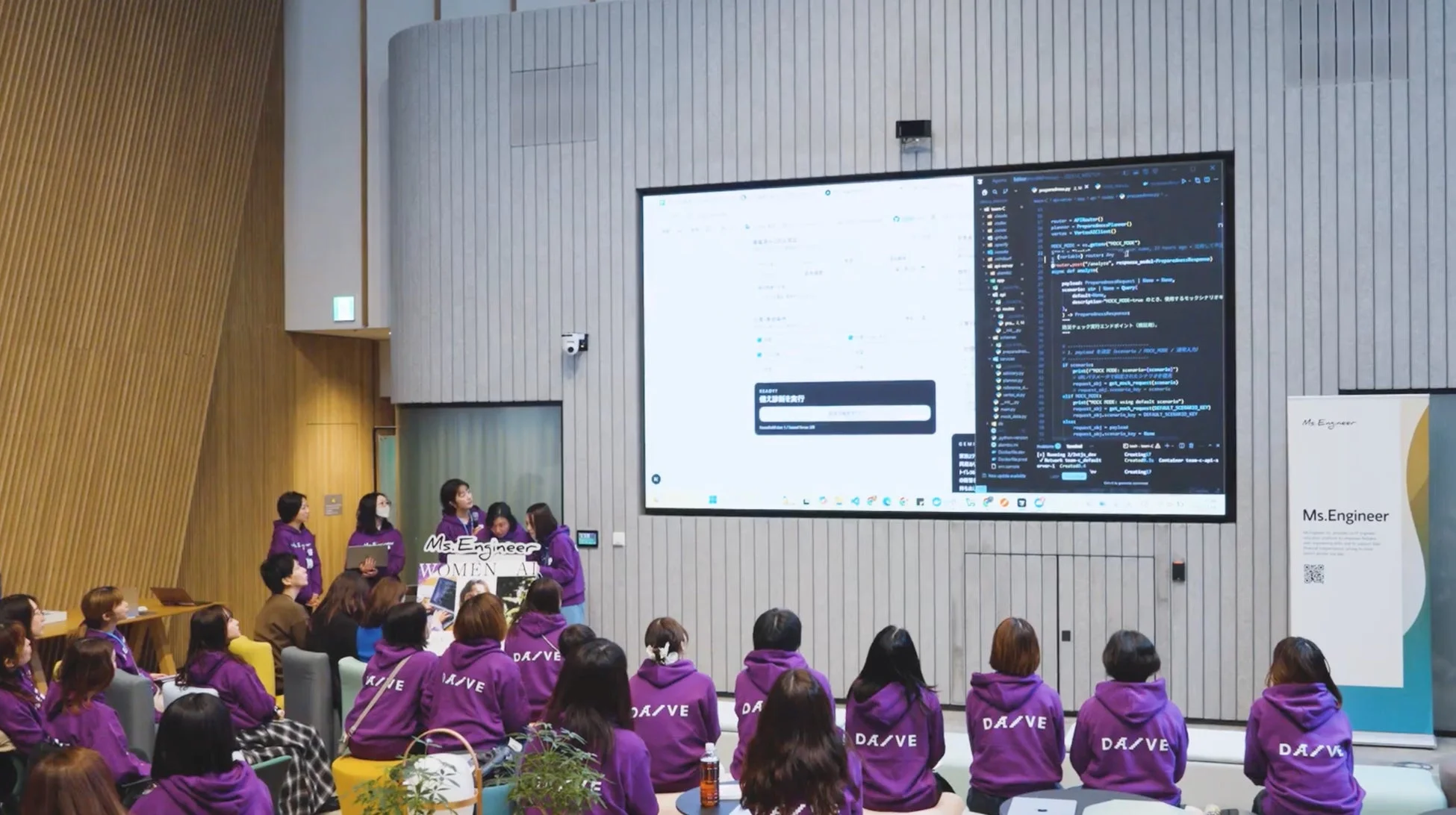 ITイベントでプログラミングコードが映し出されたスクリーン