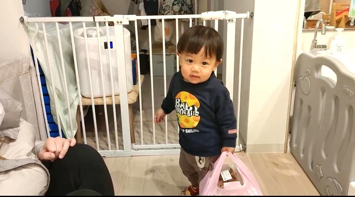 ピンクのビニール袋を持った幼児の男の子