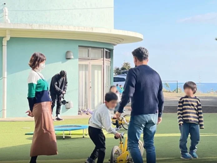 屋外で子供と大人が遊んでいる様子