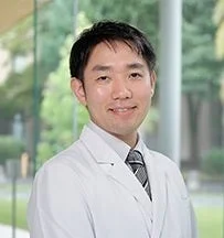 白衣を着用し笑顔の長谷井嬢教授