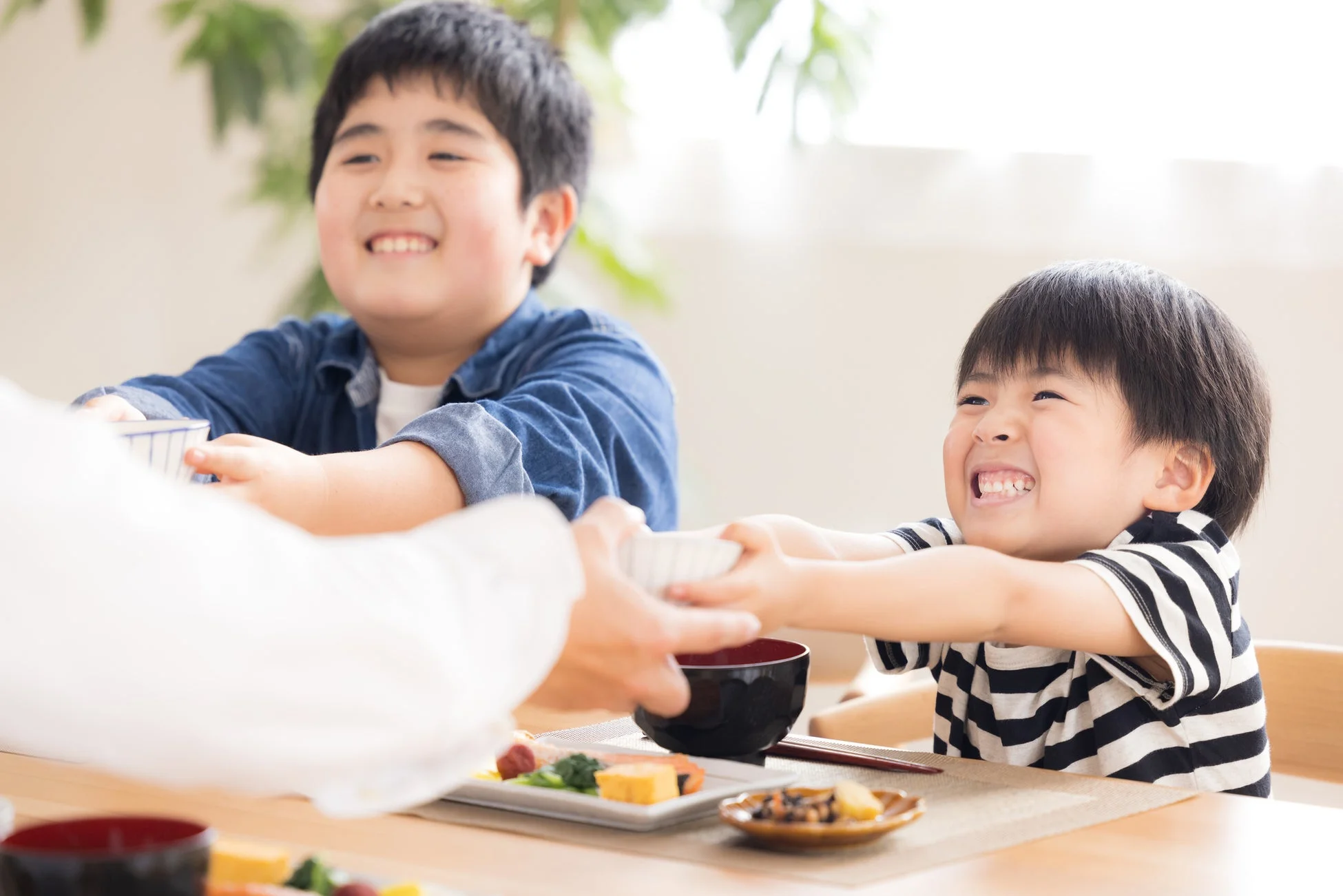 食卓で笑顔を見せる子どもたち