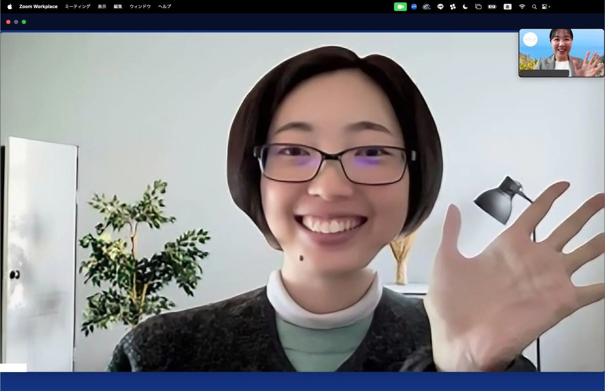 笑顔で手を振る女性が映るZoomのビデオ会議画面
