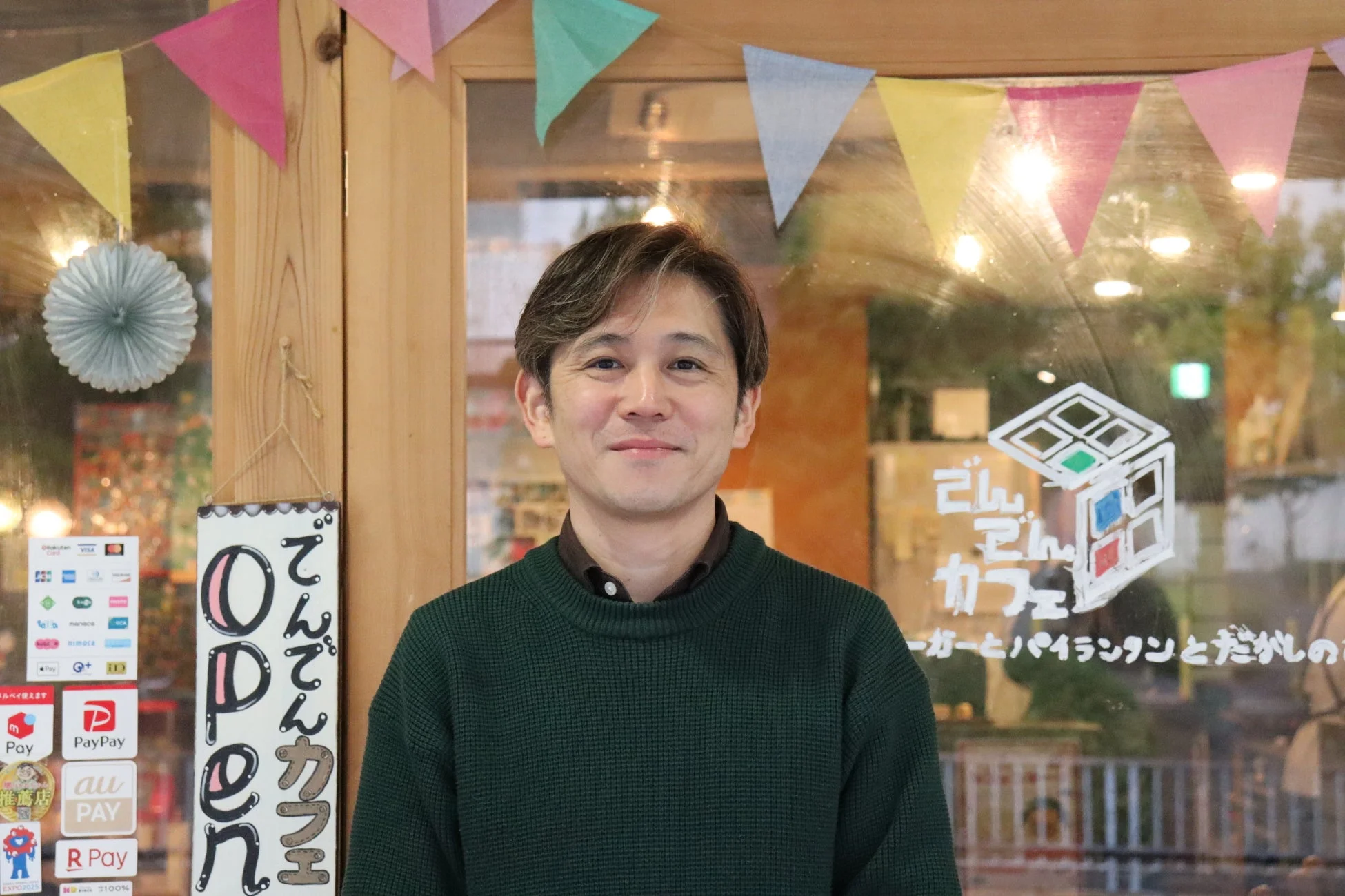 笑顔の男性、てんてんカフェの入口