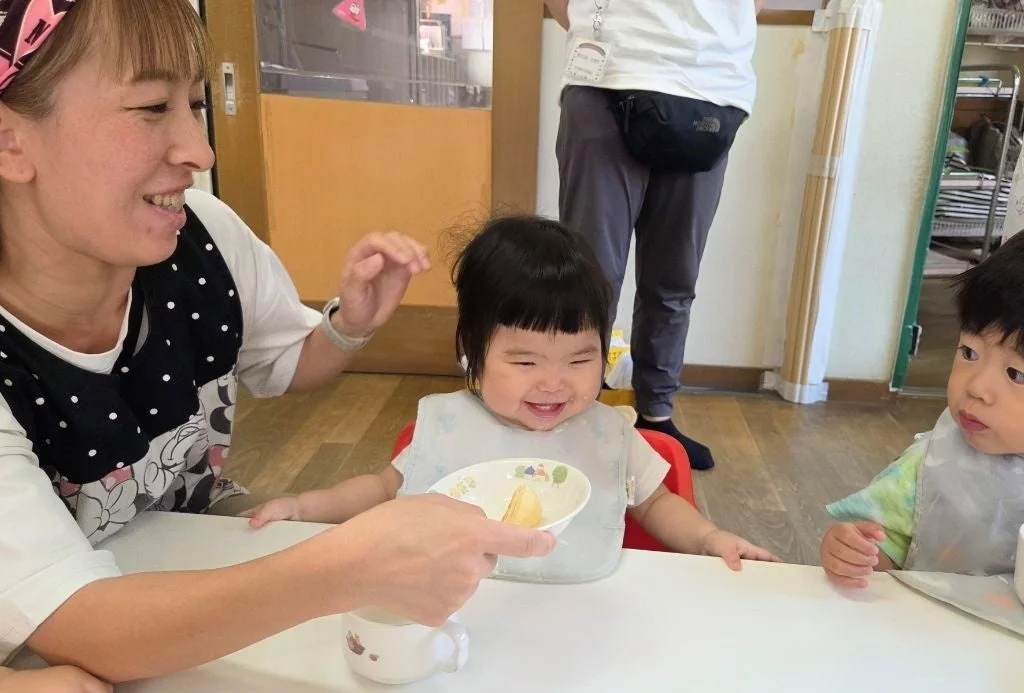 保育士が園児に食事を与えている様子