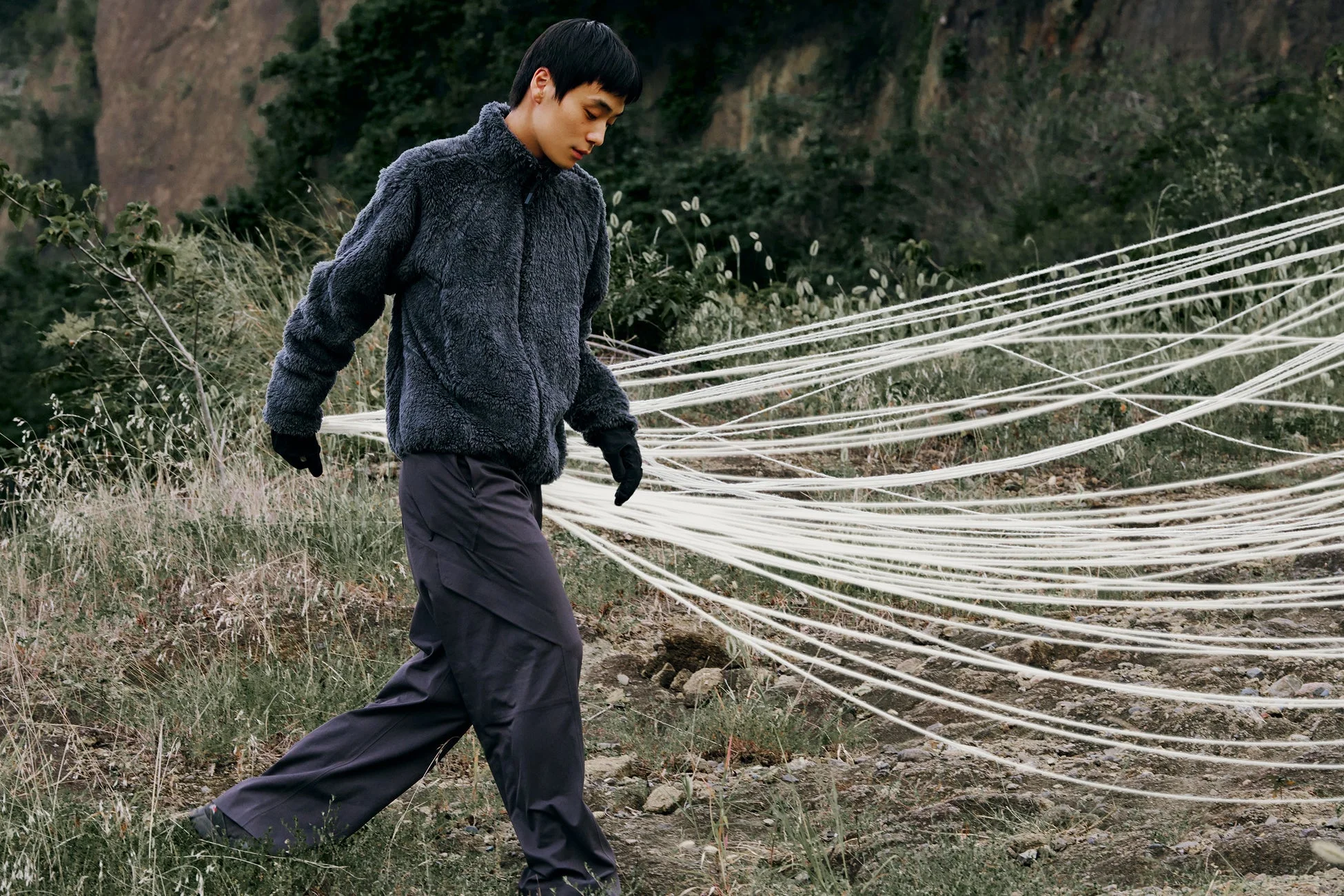 男性がフリースジャケットを着て屋外を歩いている様子