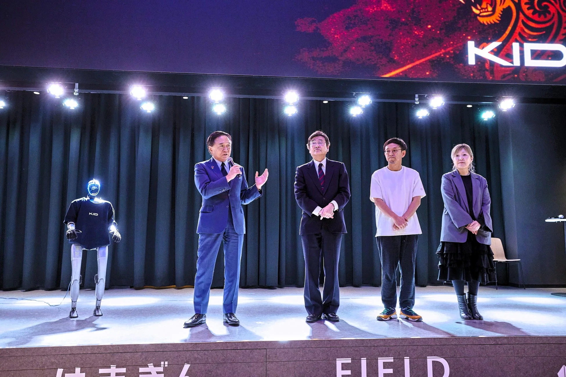 ステージでロボットと登壇者が並ぶ発表会