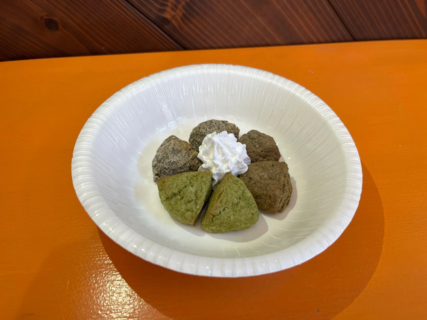 白い皿に盛られた数種類のスコーンとホイップクリーム