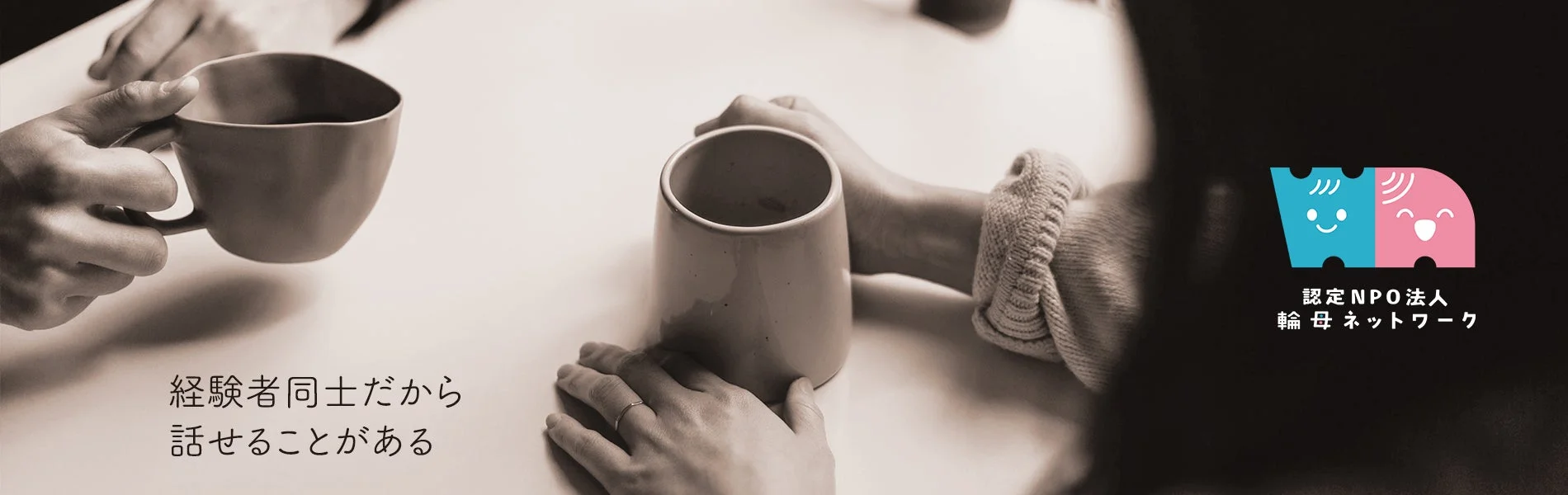 テーブルを囲んでマグカップを持つ二人の手元が写されており、経験者同士が安心して話せる場であることを示唆しています。