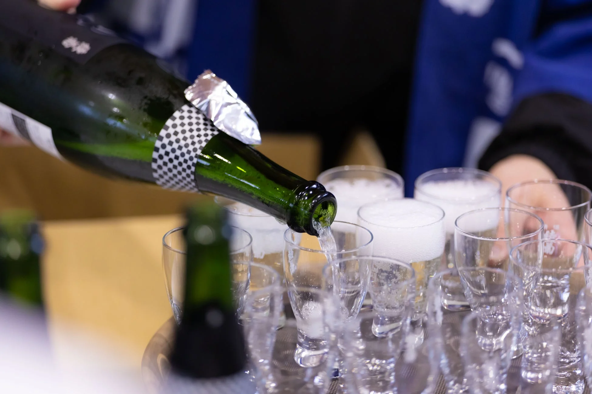 懇親会で日本酒が注がれる様子