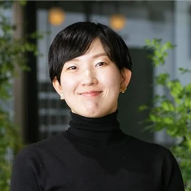 黒いタートルネックを着て微笑む女性