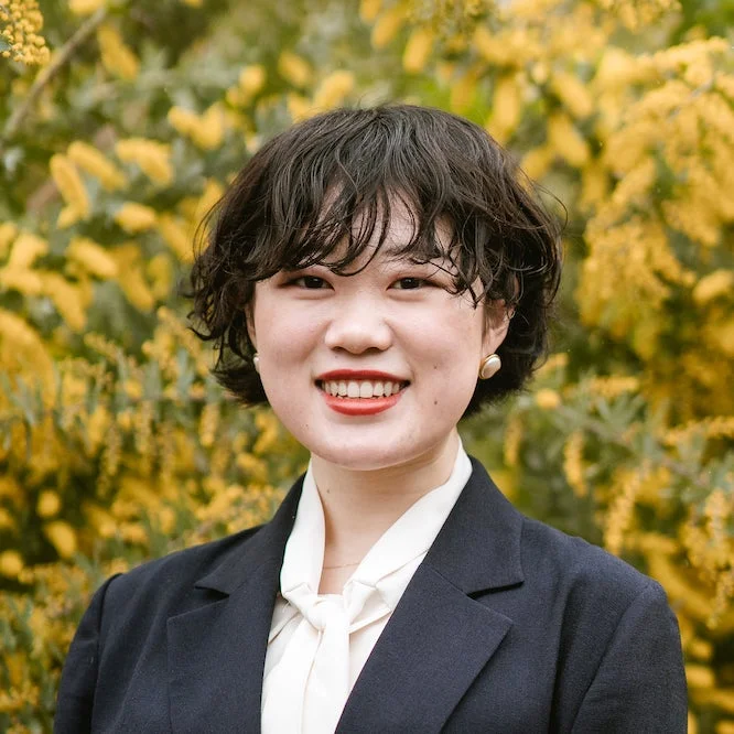 ミモザの花を背景に笑顔の女性