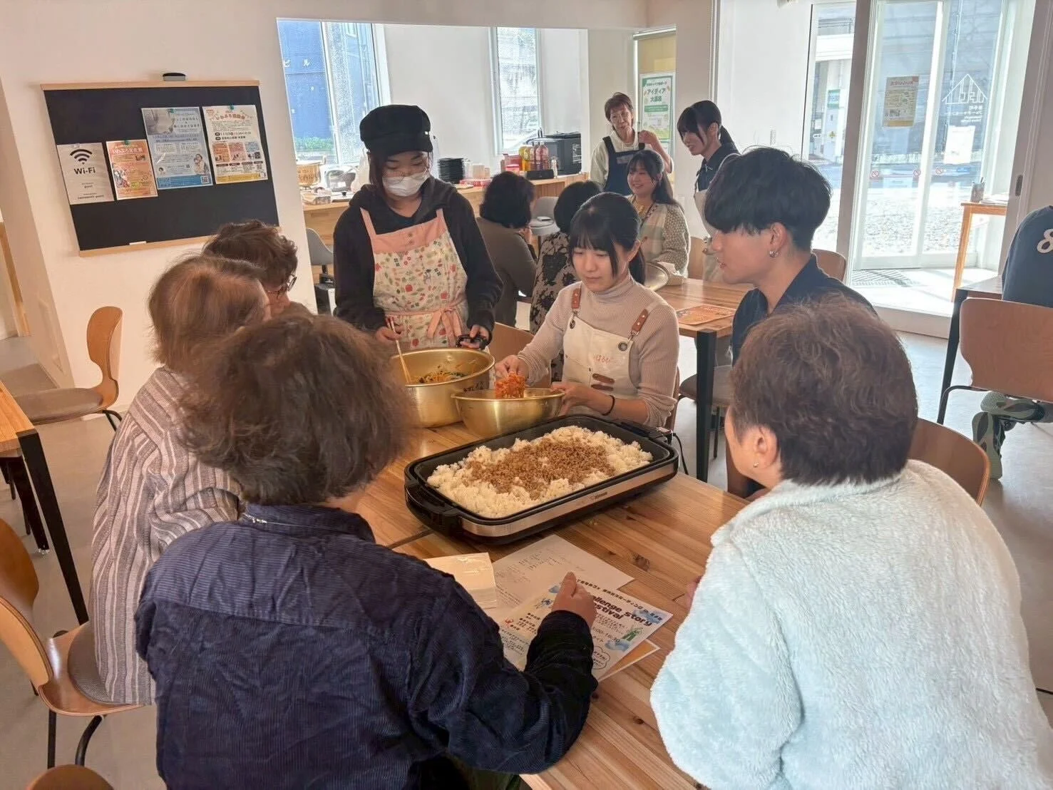 ホットプレートを囲んで料理をする人々