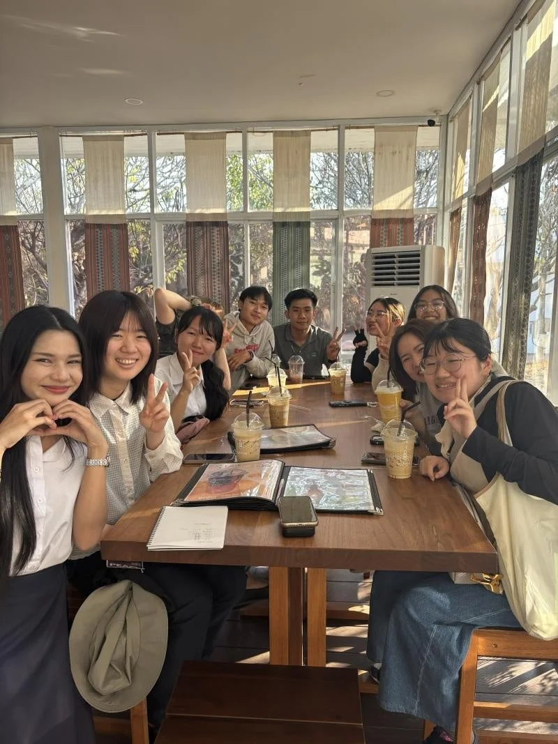 カフェで若者グループがテーブルを囲む