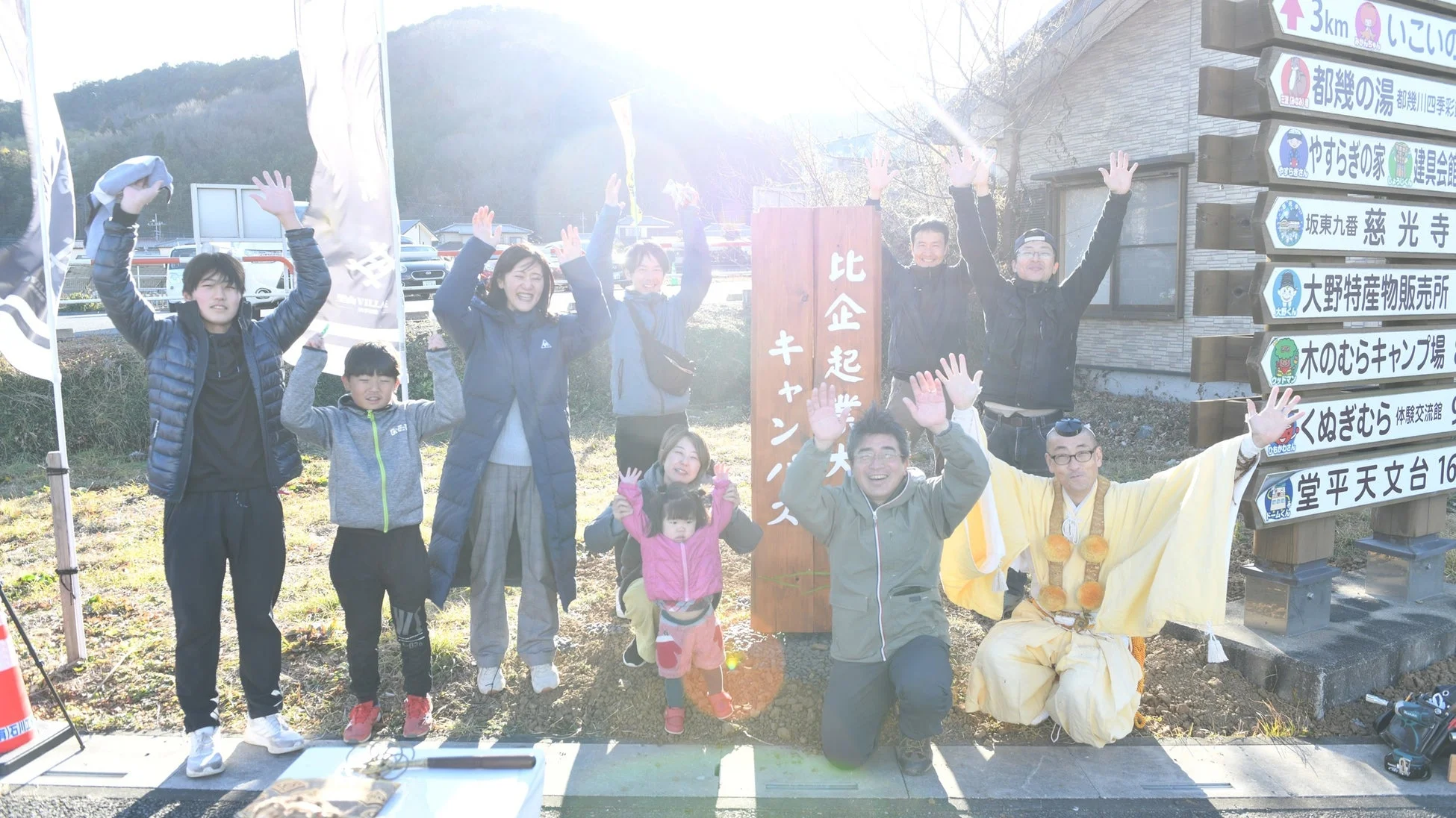 比企起業キャンパスの看板と人々の集合写真