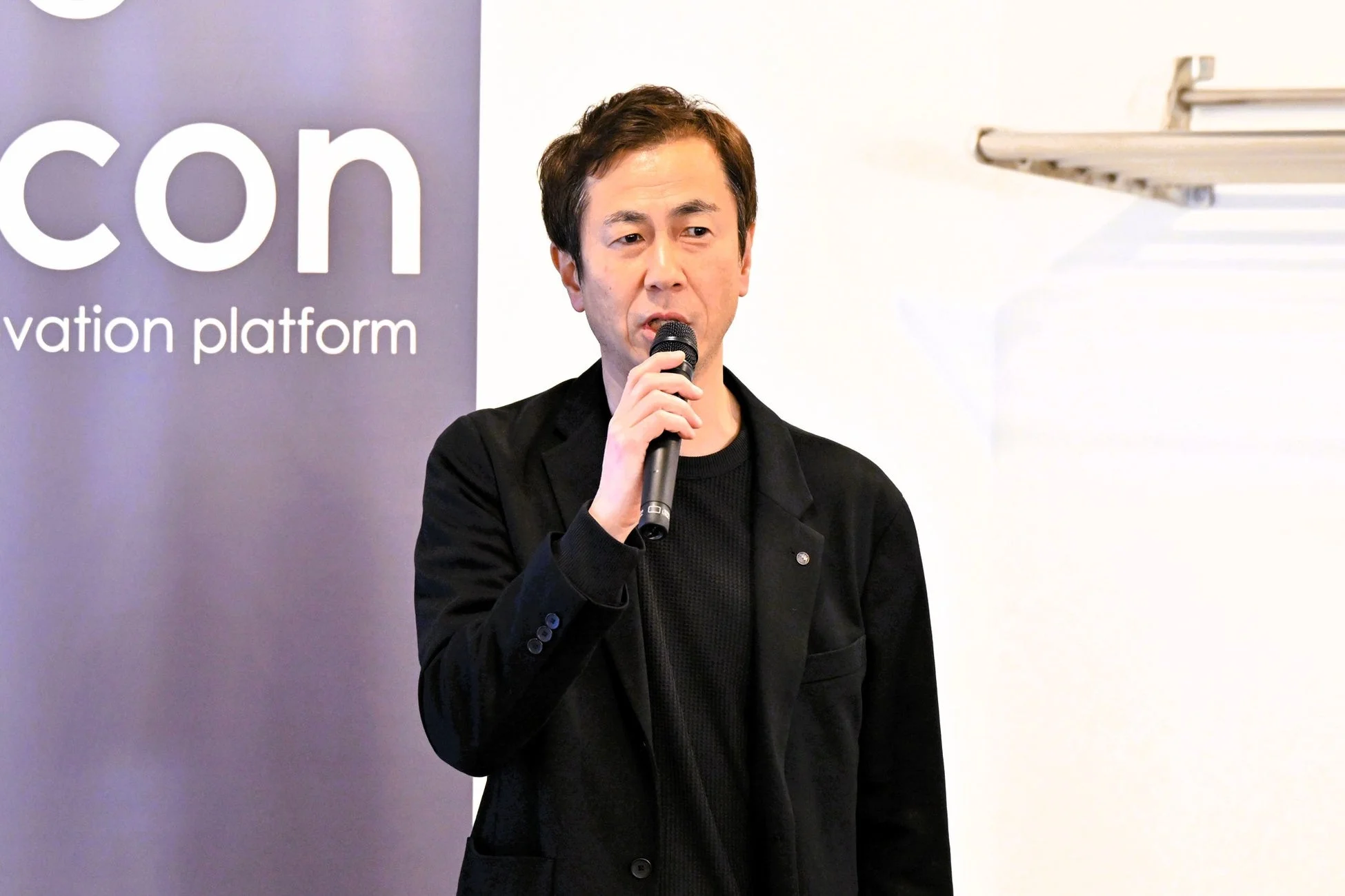 マイクを手にスピーチする男性