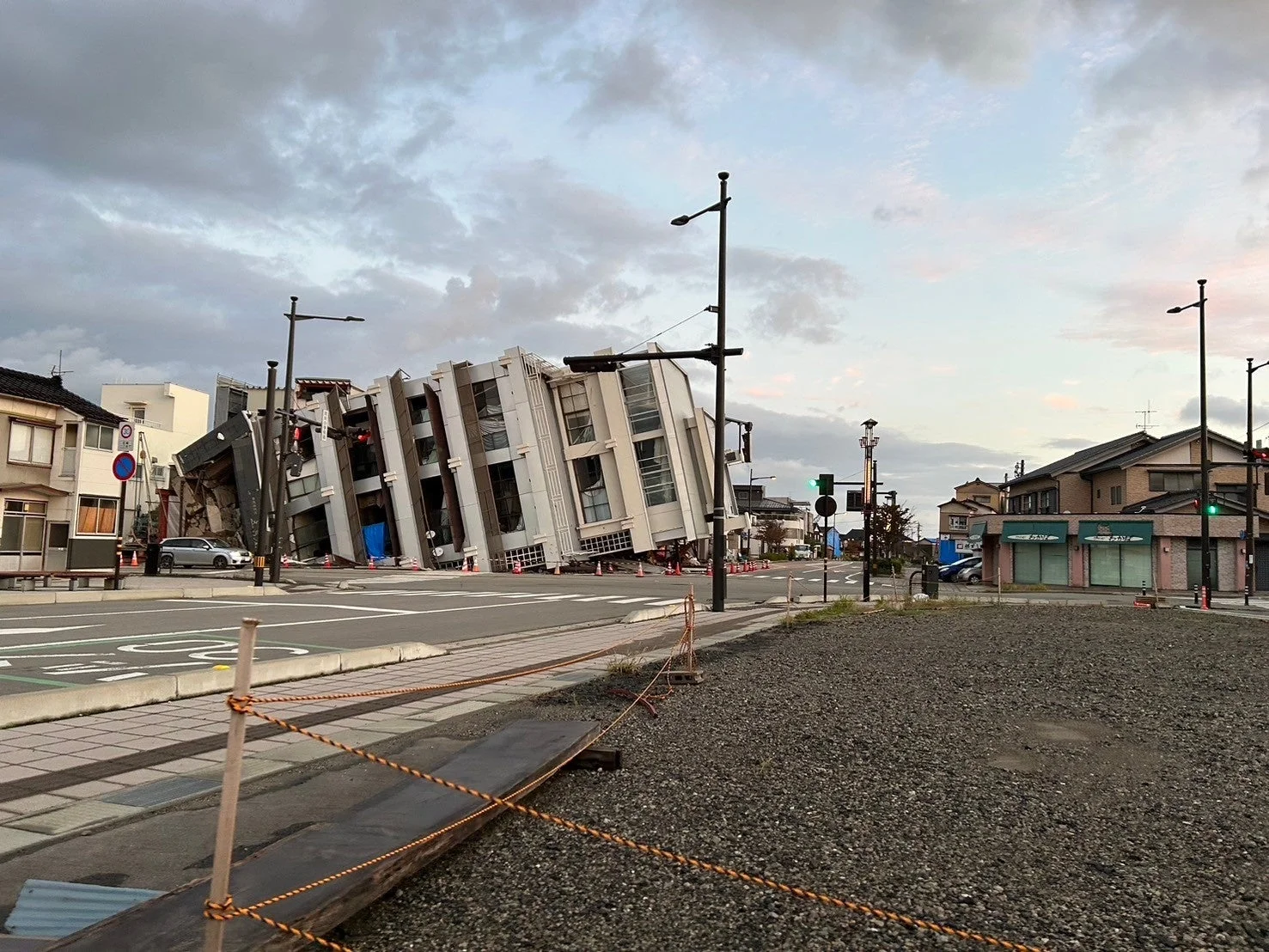 地震により大きく傾いた建物が街角に立つ様子を捉えた画像です。