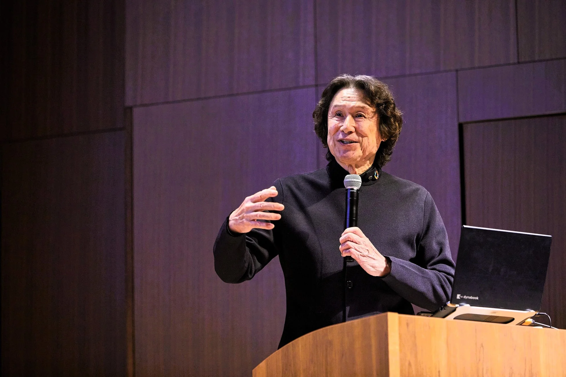 講演会でマイクを手に話す男性