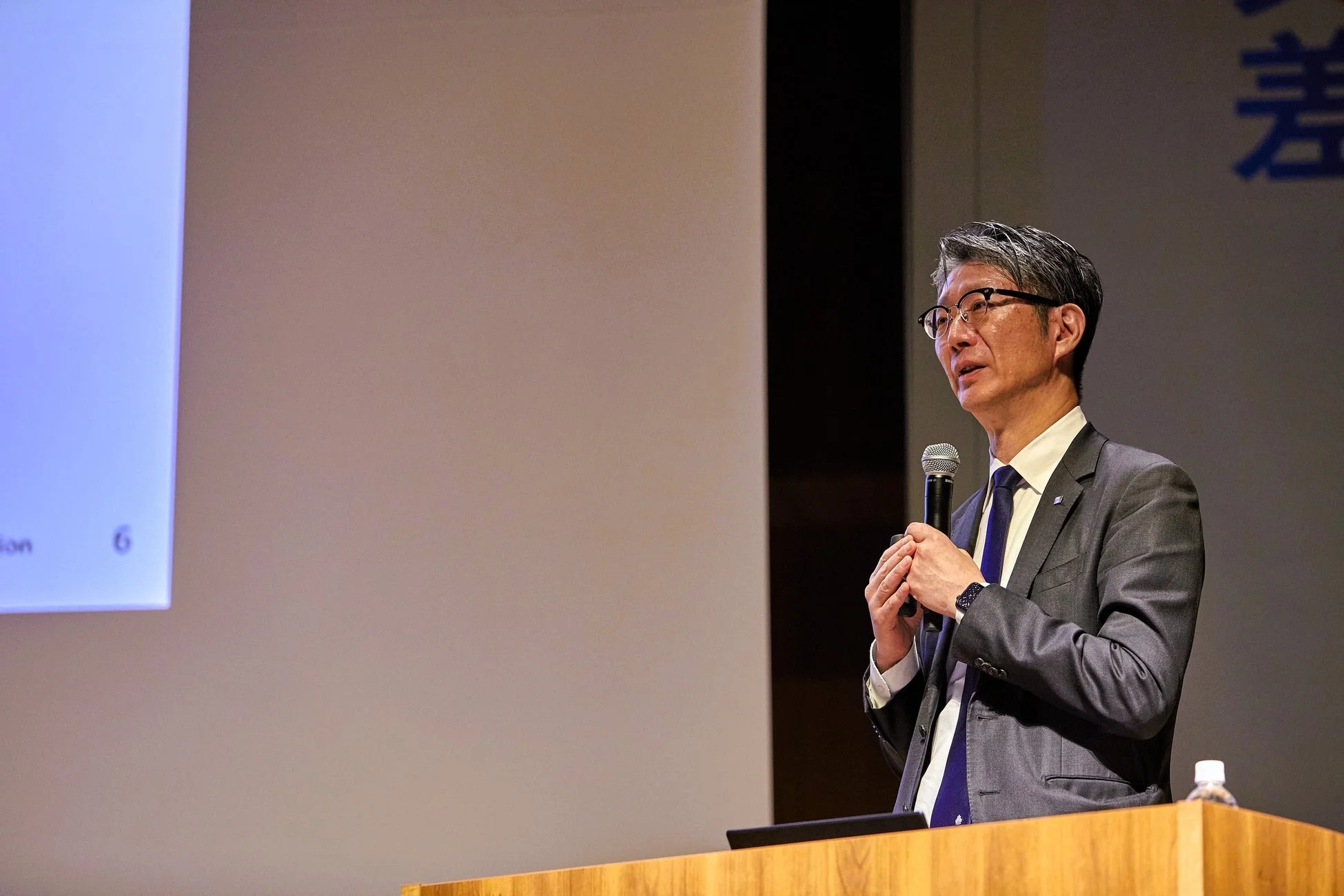 スーツ姿の男性がスピーチを行う様子