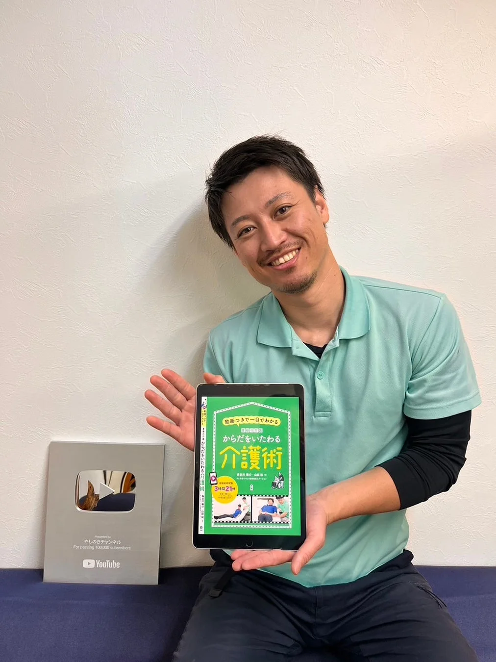 笑顔でタブレットを持つ長谷川陽介氏