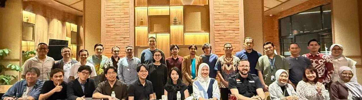 多くの男女が笑顔で集合写真に収まっています。