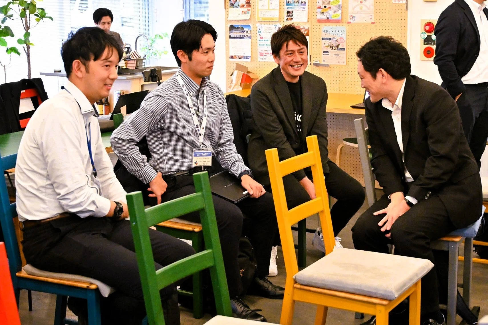 カジュアルなオフィス空間で笑顔で談笑する参加者たち