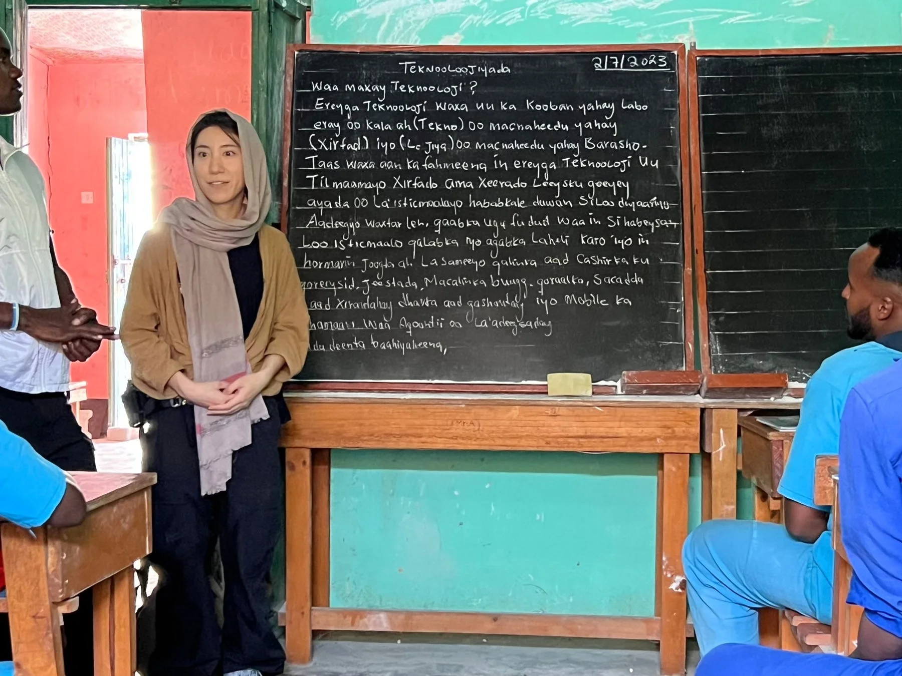 教室で、スカーフを巻いた女性がソマリ語で書かれたテクノロジーに関する内容を説明している