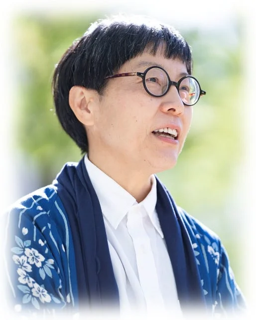 丸眼鏡をかけた短髪の女性