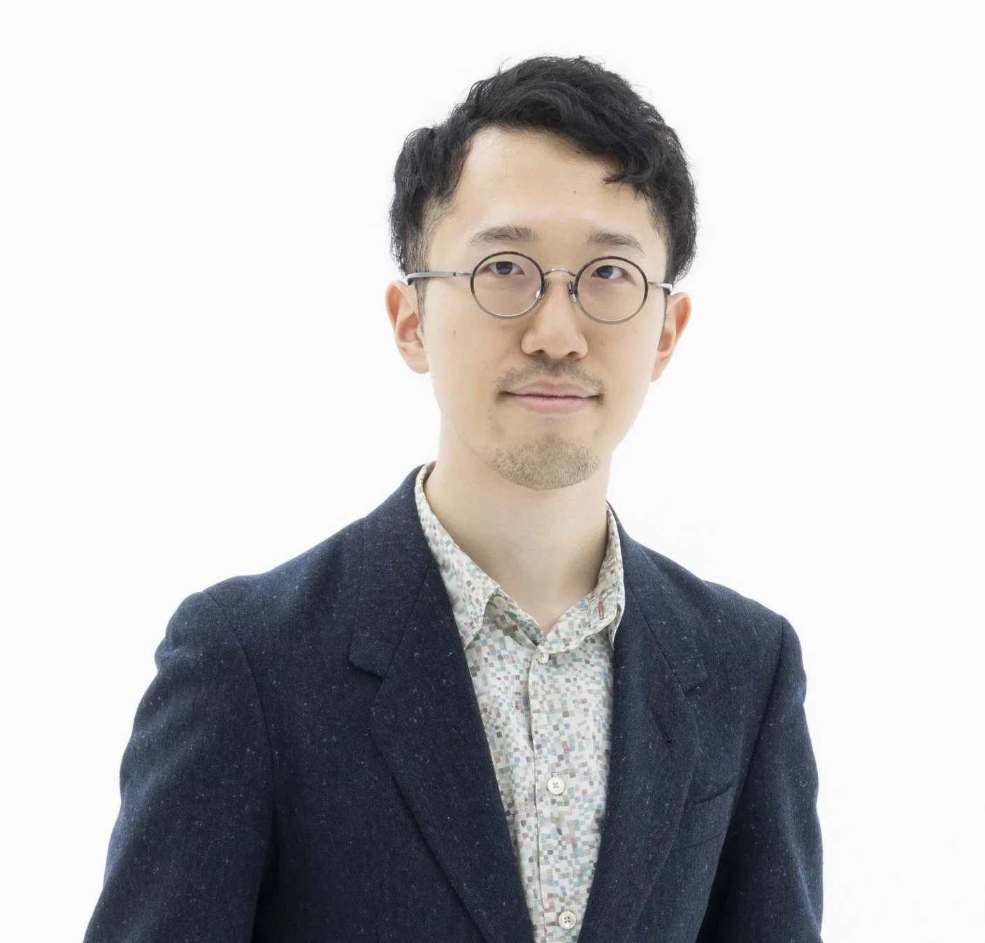 丸眼鏡をかけた若いアジア人男性のポートレート