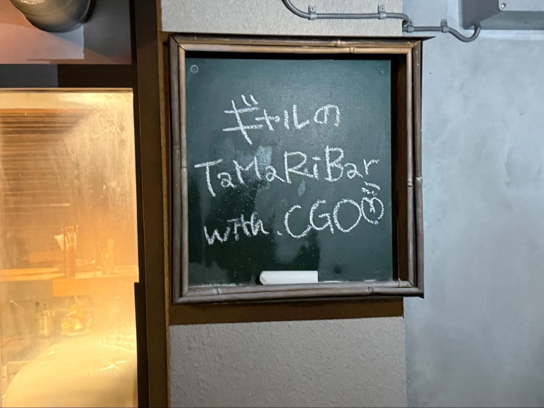チョークボードに書かれた「ギャルのTaMaRiBar with CGOÖ」