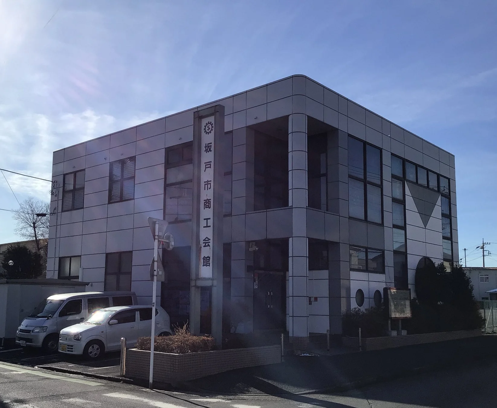 青空の下に建つ坂戸市商工会館の建物です。