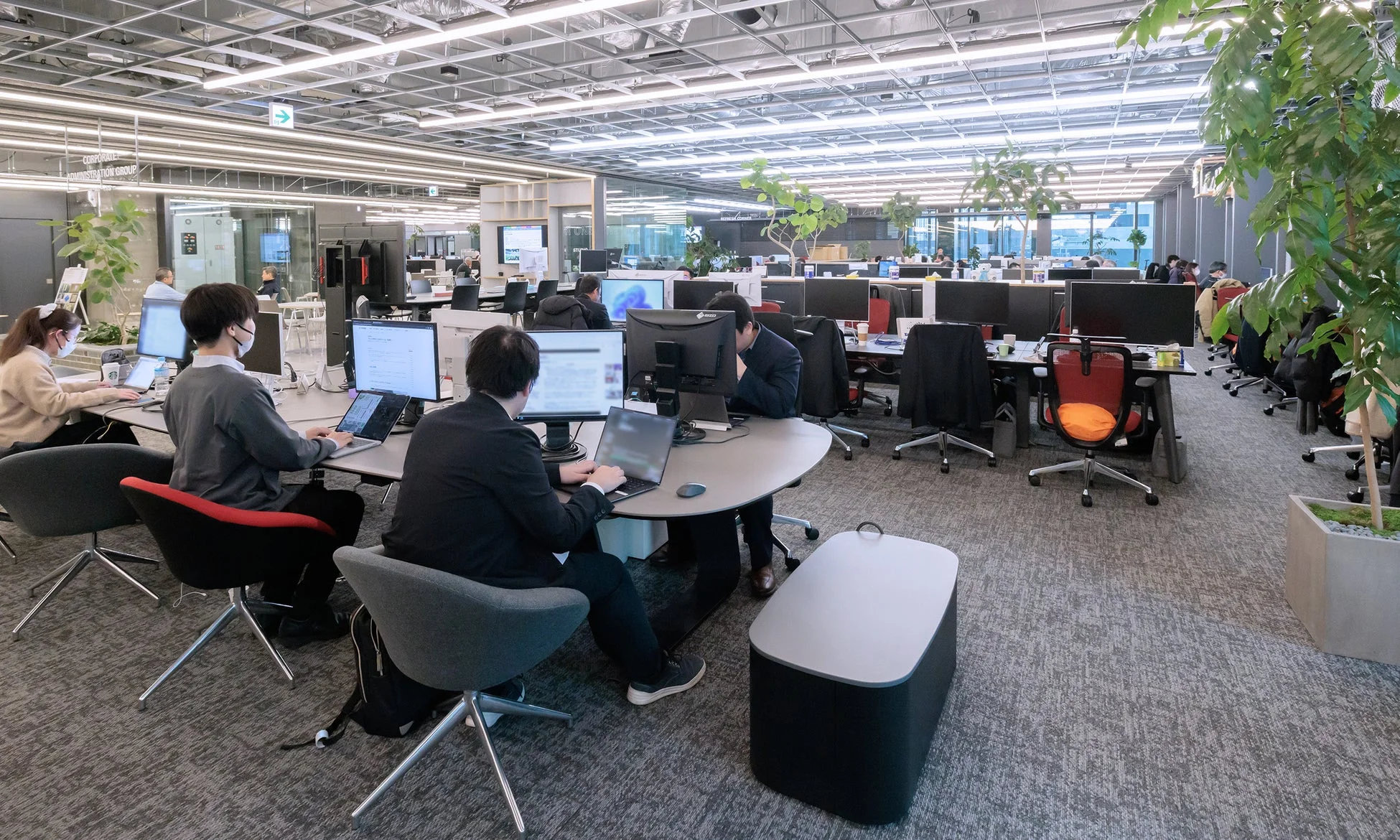 広々としたオープンオフィスで作業する人々