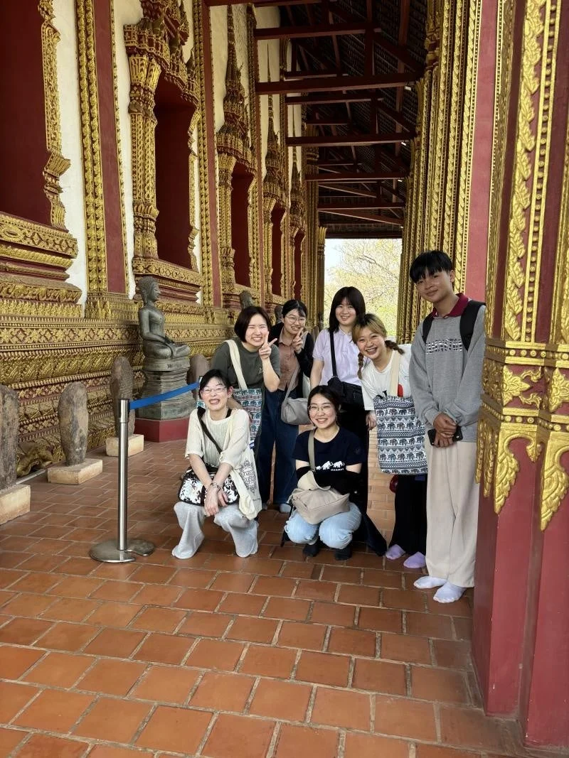 寺院で若者たちが笑顔でポーズ