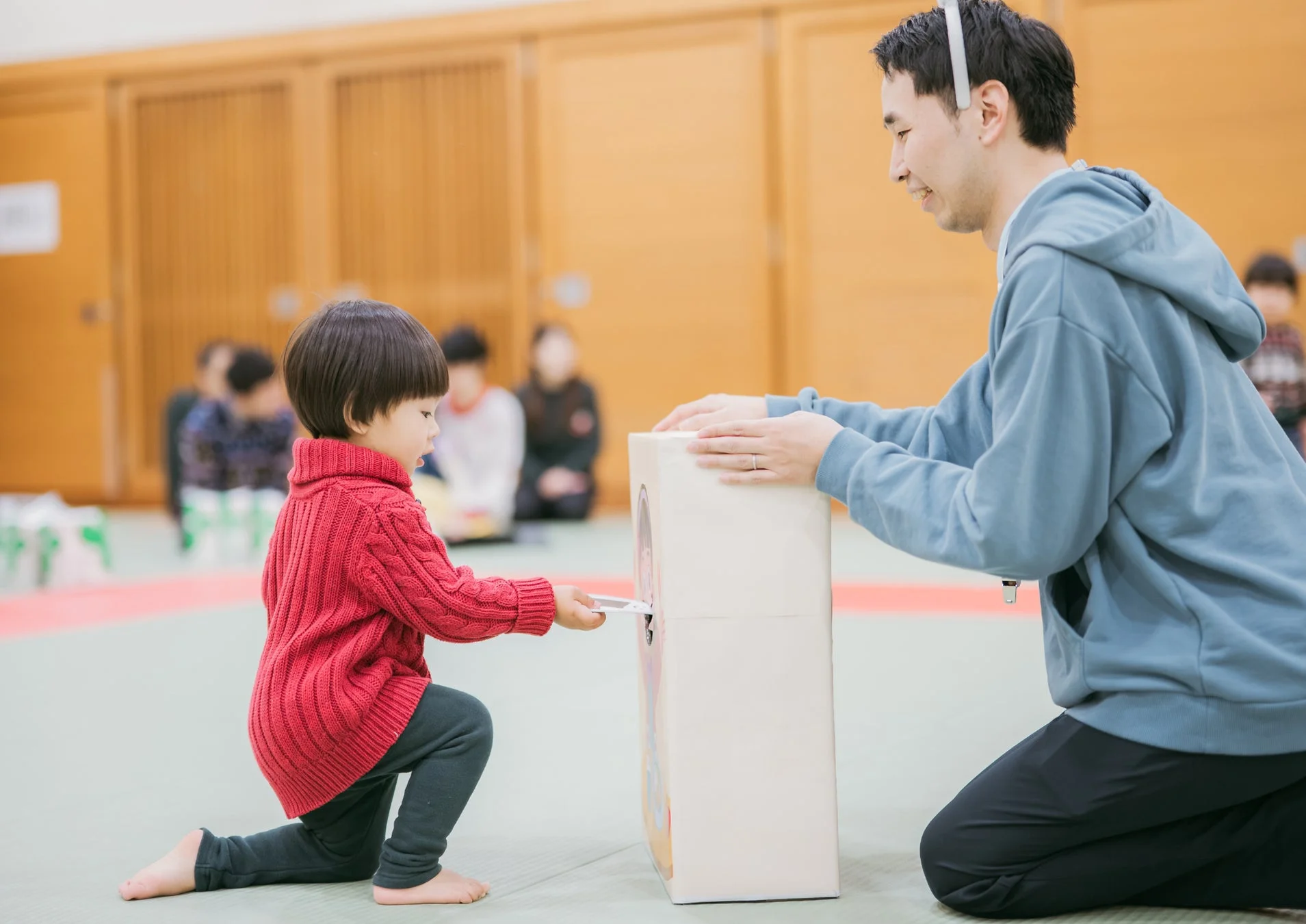 親子で箱に何かを差し込む遊びを楽しむ