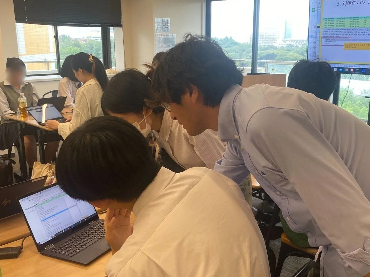 学生がノートパソコンでネットワークのパケット解析について学んでいる様子
