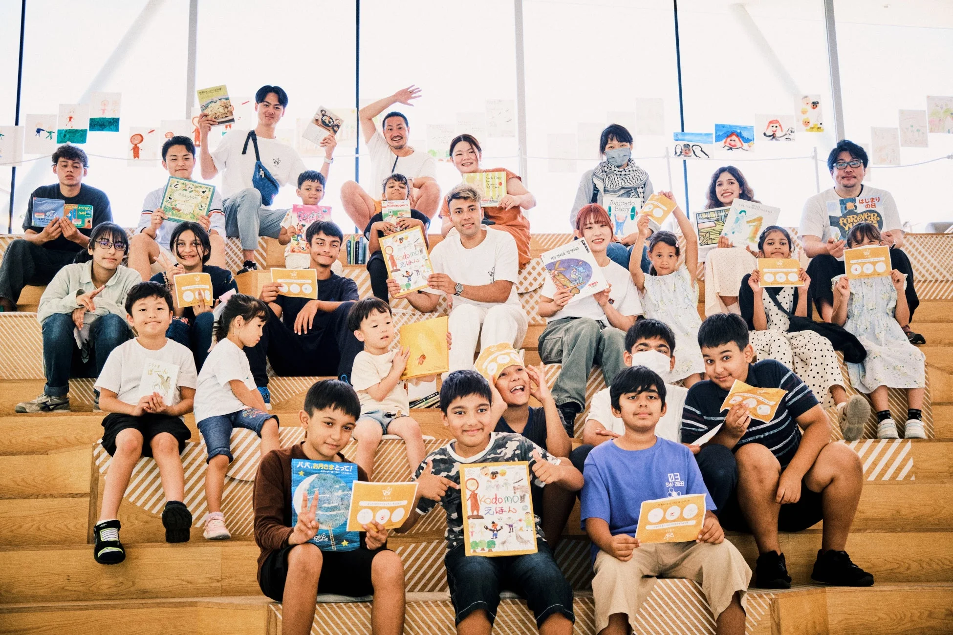 絵本を手に笑顔の子どもたちと大人たち