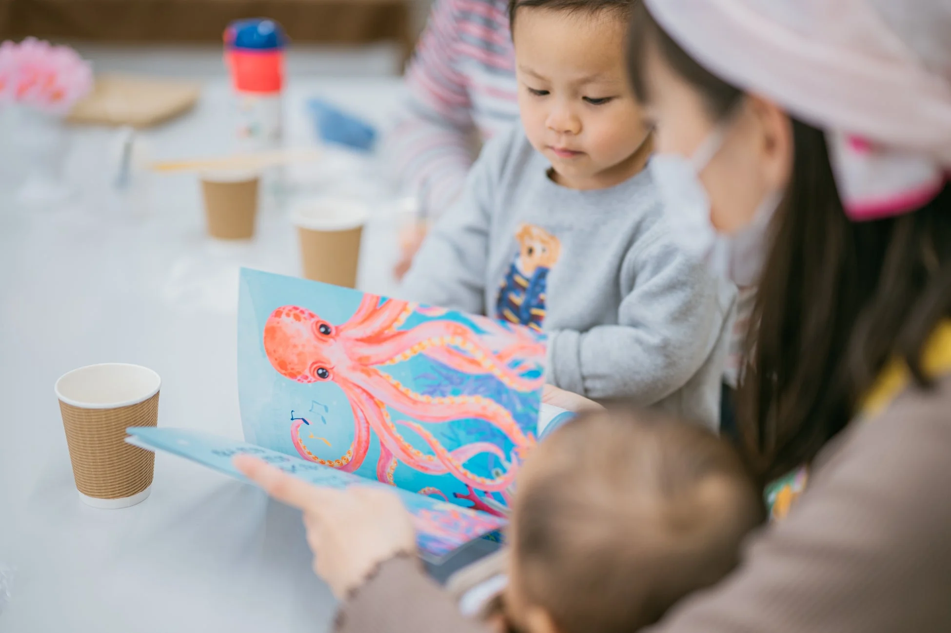 子供たちに絵本を読み聞かせる女性