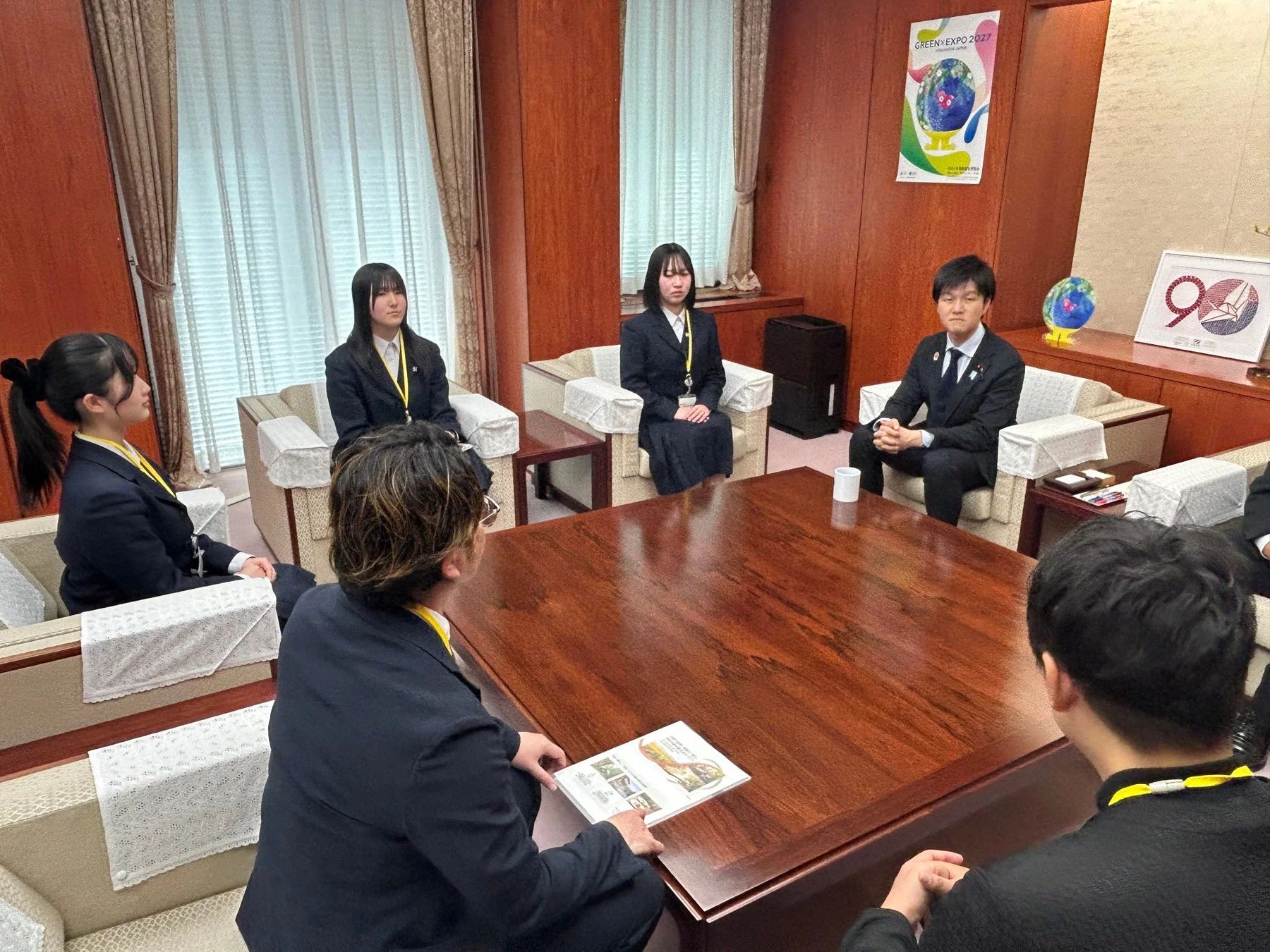 会議室で意見交換する学生と社会人