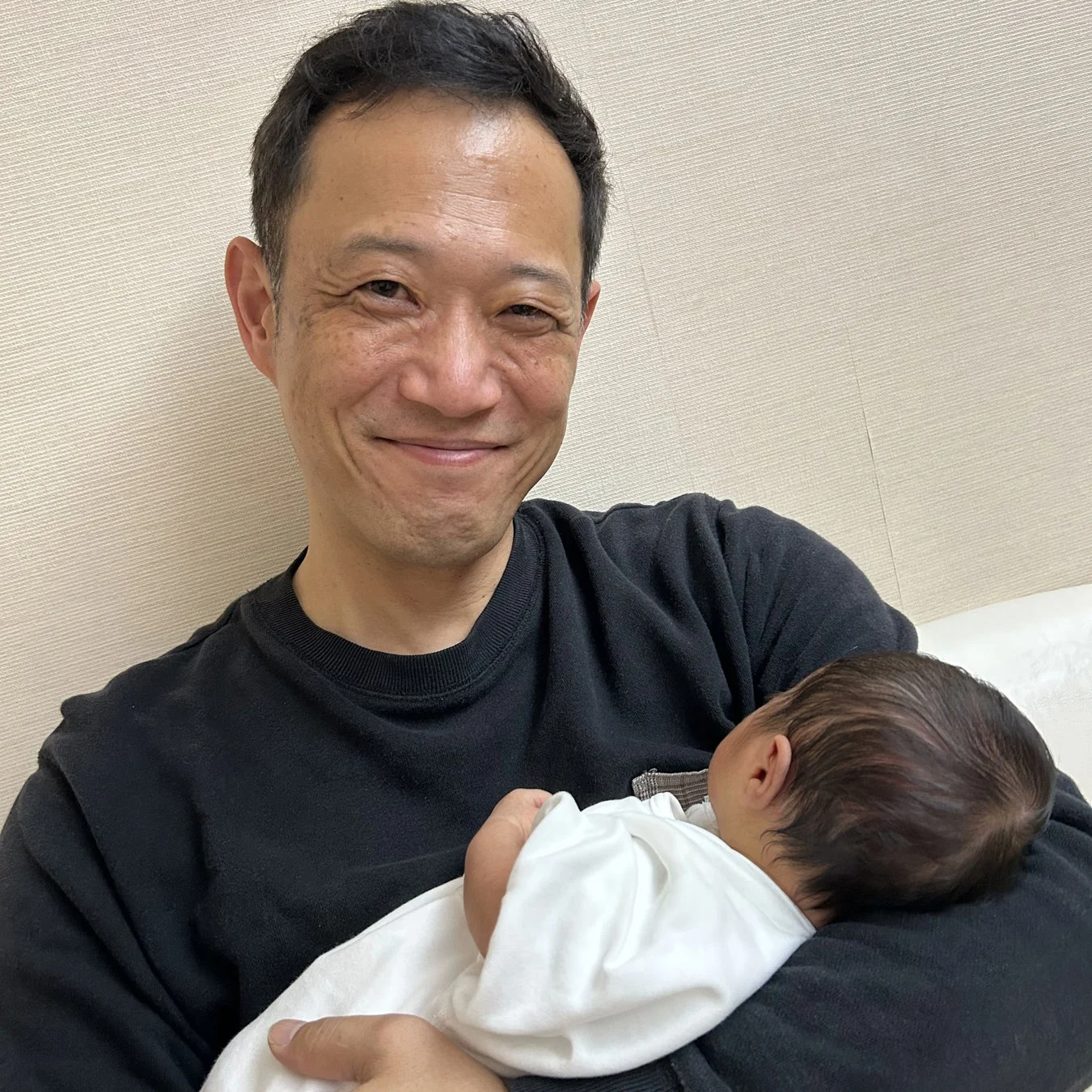赤ちゃんを抱っこする原水敦氏